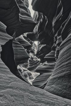 an image of the inside of a canyon in black and white with light coming through it