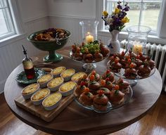 a table topped with lots of food on top of a wooden table next to a window