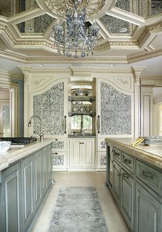 a fancy kitchen with chandelier and marble counter tops