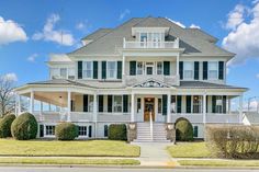 a large white house sitting on the side of a road