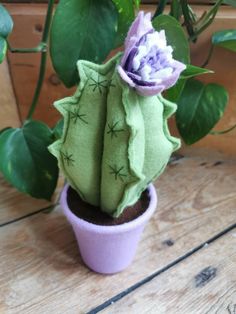 a small potted plant with a purple flower in it