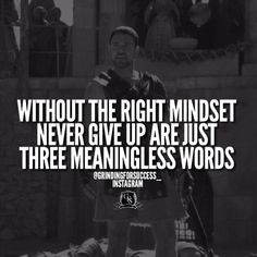 a man standing in front of a building with a quote on it that says, without the right minds never give up are just three meaningsless words