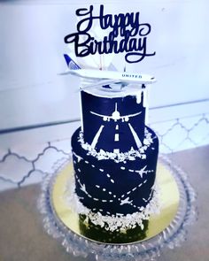 a blue and white birthday cake with an airplane on top