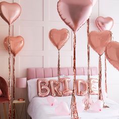 pink and gold balloons in the shape of hearts are on display at a bridal party