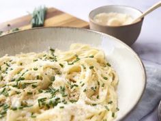 a white bowl filled with pasta and parmesan cheese