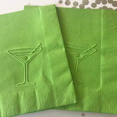 two lime green cocktail napkins sitting on top of each other next to one another