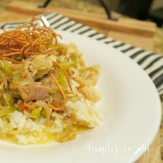 a white plate topped with rice and meat