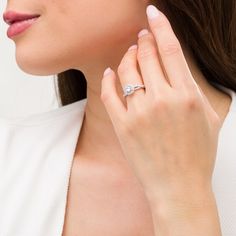 a woman wearing a diamond ring on her left hand