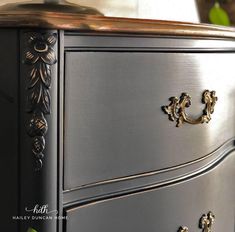 a black dresser with gold handles and knobs on it's drawers is seen in this image