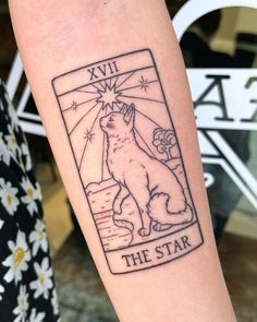 a cat tattoo on the arm that reads,'the star'with an image of a cat