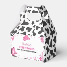 a black and white cow print paper bag with pink accents on the front, featuring an image of a cow pattern