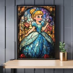 a stained glass window with a princess sitting on it's shelf next to a potted plant