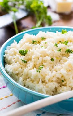 a blue bowl filled with rice on top of a table