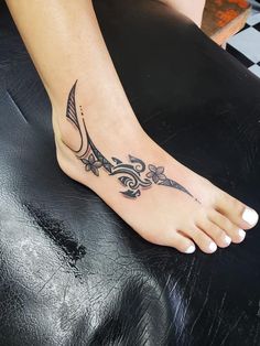 a woman's foot with a tattoo design on the top and bottom of it