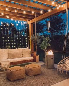 an outdoor living room with lights strung from the ceiling