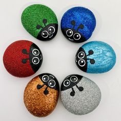 six painted rocks with ladybugs on them in the shape of four different colors