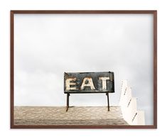 an old sign that says eat on top of a roof next to some white stairs