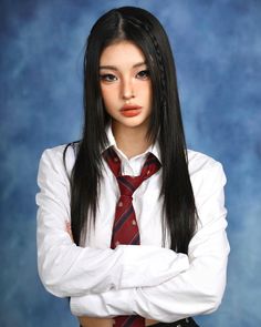 a young woman with long black hair wearing a white shirt and red tie, standing in front of a blue background