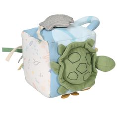 a stuffed turtle is sitting on top of a small box with its mouth open and eyes closed