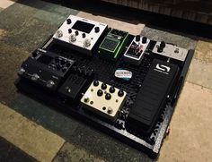 several different types of pedals sitting on top of a black box with white and green knobs