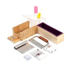 a wooden box with tools and paper in it on a white surface, next to some other items