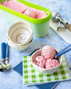 a bowl filled with ice cream sitting on top of a table next to other items