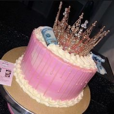 there is a pink cake with gold crown on top and price tag next to it