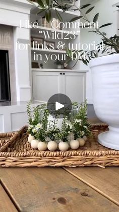 a basket with flowers and eggs in it sitting on a table next to a vase