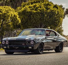 an old muscle car is parked on the street