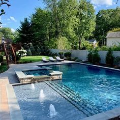 an outdoor swimming pool surrounded by greenery and trees, with lounge chairs around it