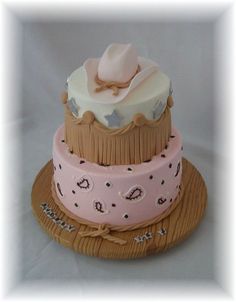 a three tiered cake decorated with pink and brown icing