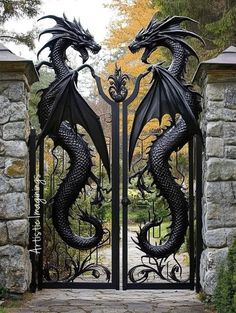 an iron gate with two black dragon statues on it