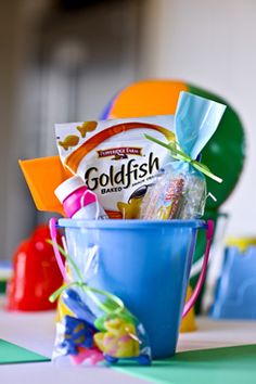 a blue bucket filled with candy and other items