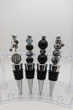 a clear display case with black and silver items on it's sides, all in different shapes and sizes