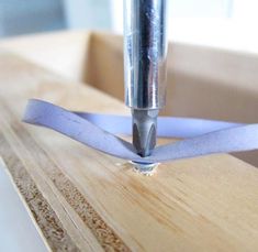 a close up of a piece of wood with a blue ribbon attached to the end