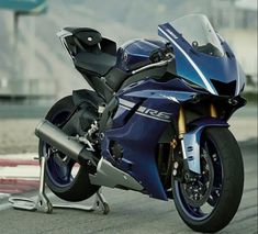 a blue motorcycle parked on top of a race track