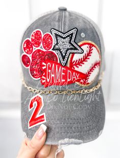 someone is holding up a baseball cap with the word game day on it and a paw print