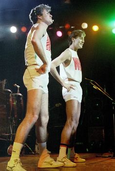 two men standing on stage in shorts and socks