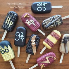 there are many different types of cake pops on the wooden table with numbers painted on them