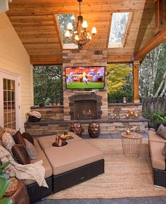 an outdoor living area with couches and television