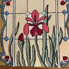 a close up of a cross stitch pattern with flowers