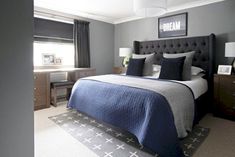 a bedroom with gray walls and blue bedding