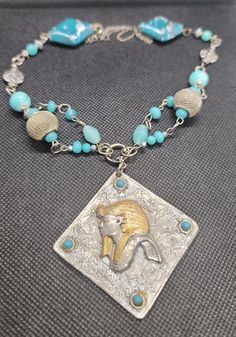 Beautiful and one of a kind, hand made silver and turquoise colored beads featured by a vintage pendant that has a unique image of an Ancient Egyptian King. The beads I used are silver,  stone, crystal and pottery.   The pendant measures 3 inches by 3 inches.   The necklace length is adjustable.  I love this necklace, I hope you will too!  Gift wrapped year round! Egyptian Kings, Unique Image, Turquoise Color, Ancient Egyptian, Turquoise Necklace, Necklace Lengths, Turquoise, Beads, Stone