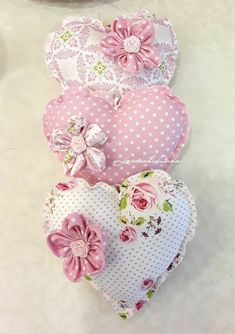 three heart shaped cushions sitting on top of a table