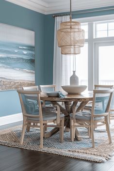 a dining room with blue walls and wooden floors