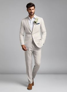 a man in a white suit and tan shoes