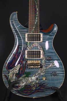 a blue guitar with an intricate design on it