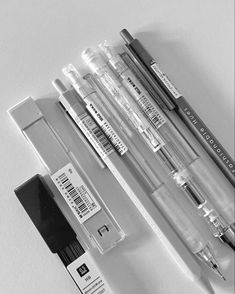 several different types of pens and ink on a white surface