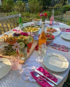 a table set with plates, silverware and flowers in vases on the table