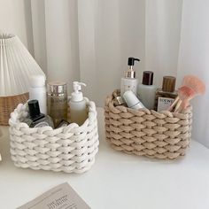 a white table topped with two baskets filled with personal care items next to a book